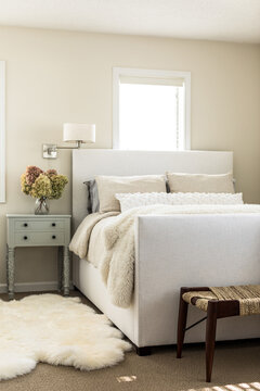 Bedroom with white upholstered bed and fluffy throw