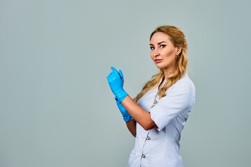 a female doctor in a white coat and blue gloves