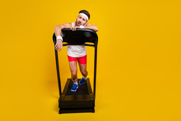 Full body photo of unsatisfied tired person struggle treadmill empty space ad isolated on yellow...