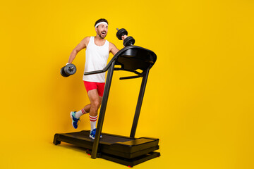 Full length profile photo of sportive funky guy hold dumbbells run treadmill empty space ad...
