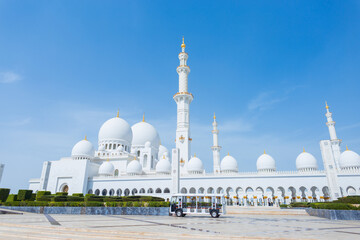 Fototapeta na wymiar Sheikh Zayed Grand Mosque Centre. Beautiful mosque with minibus on a sunny day in Abu Dhabi