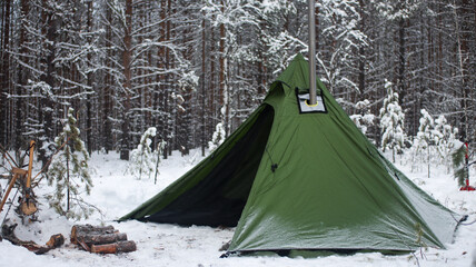 Winter camping in the Boreal Forest. Hot tent. Tipi stands in the winter forest. Ecotourism