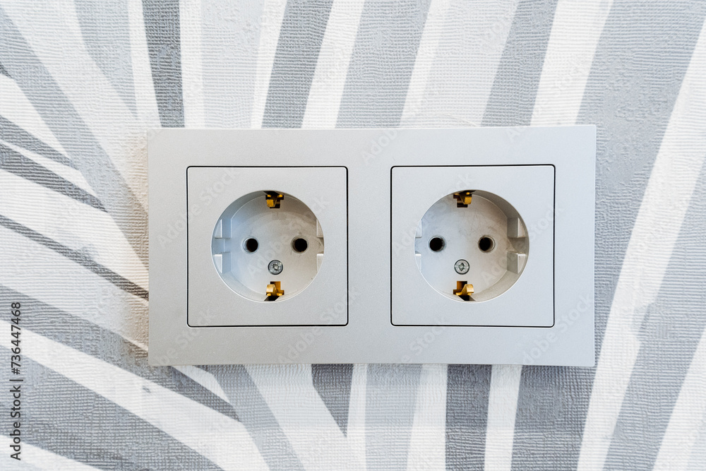 Wall mural two white electrical outlets mounted on a striped wall