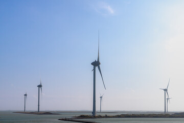 White wind turbine on the dunes with blue sky, The Delta Works is a projects to protect a large...
