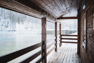 a wooden porch with a view of a lake in the winter