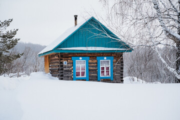 Charming cottage with a blue roof nestled in the snowy landscape