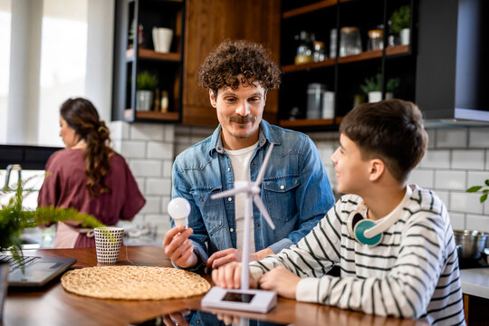 Latino family learning about sustaiable energy. Looking at windmill.