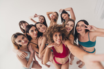 No filter studio photo of shiny funny women wear underwear showing v-sing tacking selfie enjoying girls power isolated beige color wall background