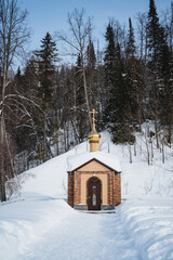 a small church in the middle of a snowy forest