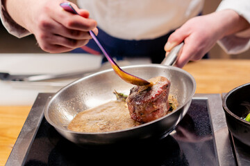 close-up of seared beef steak with rosemary topped with melted butter in frying pan