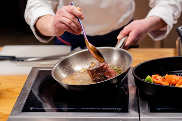 close-up of seared beef steak with rosemary topped with melted butter in frying pan