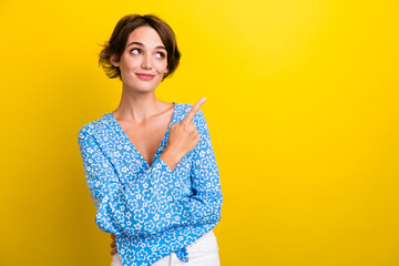 Photo of dreamy charming woman wear flower print blouse pointing finger looking empty space...