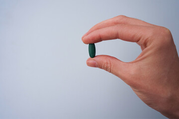 hand with pills green chlorophyll