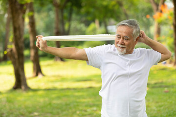 asian senior man workout and stretching with white towel in the park - obrazy, fototapety, plakaty