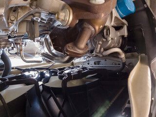View of the car radiator fans and engine cooling system from below. Mechanic view of the front of...