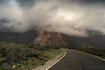 Road in San Sartolome de Tirajana with Tirajana mountains covered by low storm clouds in the background. Gran Canaria. Canary Islands
