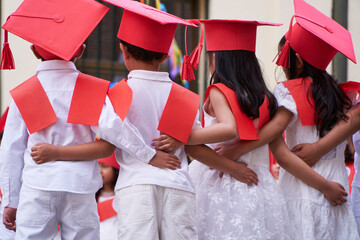 Latin pre primary children students embracing together after their graduation to get into...