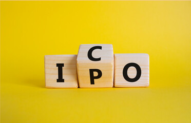 ICO and IPO symbol. Wooden cubes with words ICO - initial coin offering and IPO - initial public...