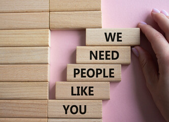 Hiring symbol. Wooden blocks with words We need People like You. Businessman hand. Beautiful pink...