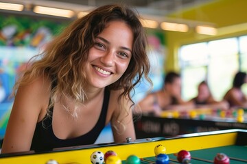 A cheerful woman enjoys a game of tabletop in her stylish recreation room, beaming with joy as she plays with a ball indoors at the leisure centre