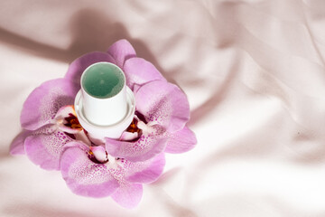 Natural liquid laundry detergent with a floral scent on a background of satin fabric.