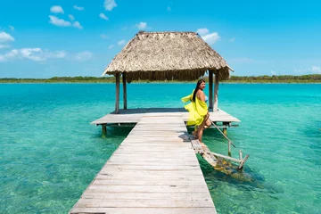 Foto op Canvas Chica joven en muelle en traje de baño amarillo de vacaciones bajando escalones a la laguna de bacalar © Misael Muñoz
