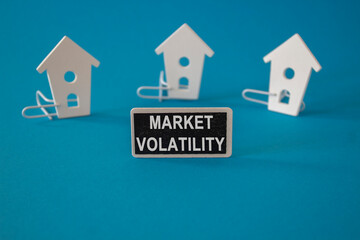 Market volatility symbol. Concept words Market volatility on black blackboard near miniature houses. Beautiful blue background. Business marketing concept.