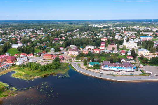 Panoramic aerial view of small Russian town of Myshkin in Yaroslavl Oblast on bank of Volga river on sunny summer day overlooking residential buildings, churches and river station