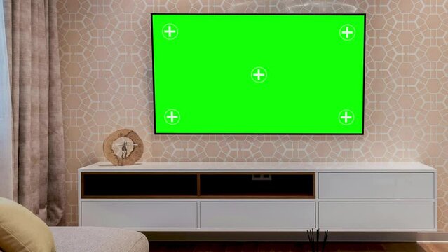 LED smart TV screen with a blank green background in the living room. Chroma key screen for advertising. Mock Up Green Screen Chromakey Display with Isolated Placeholder.