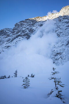 Emerging small avalanche cascading down the Tamar Valley, highlighting the dangers of mountains in the winter season.