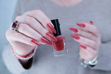 Female hands with long nails and dark red nail polish