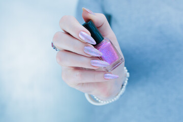 Woman hand with long nails manicure and light blue and pink nail polish