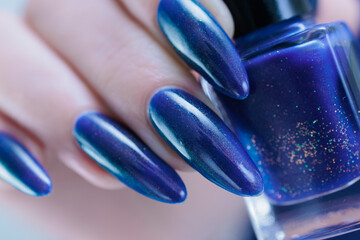 Woman's beautiful hand with long nails and dark blue manicure