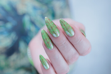 Female hand with long nails and light green manicure