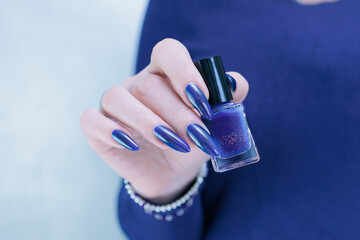 Woman's beautiful hand with long nails and bright blue manicure