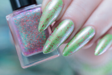 Female hand with long nails and light green manicure