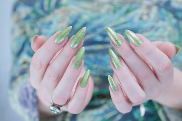 Female hand with long nails and light green manicure