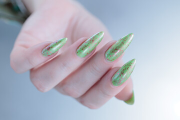 Female hand with long nails and light green manicure