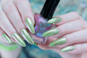 Female hand with long nails and light green manicure
