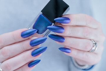 Woman's beautiful hand with long nails and blue and purple nail polish