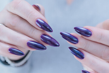 Female hands with long nails and purple manicure 