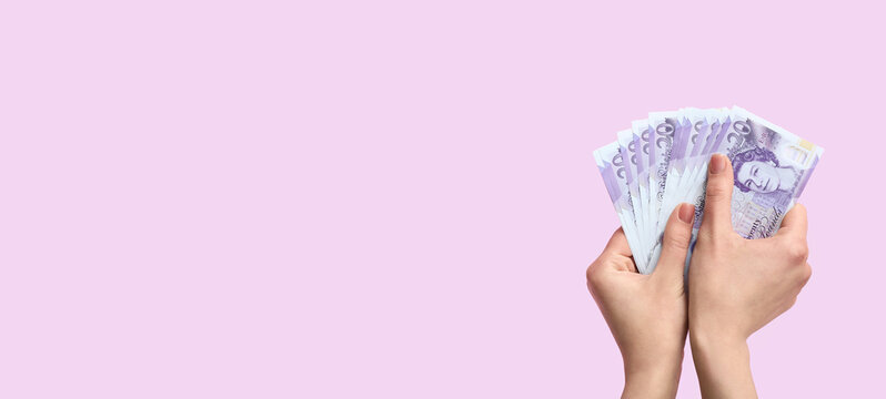 Female hands holding money on lilac background with space for text