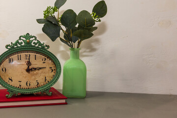 still life with clock and Eucalyptus leaves in vase, white background, daylight savings time...