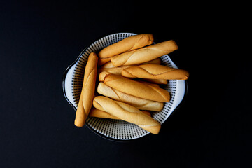 Spanish rolls Picos Camperos in a bowl on a black background - obrazy, fototapety, plakaty
