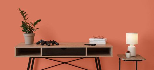 Interior of stylish room with modern TV stand near orange wall