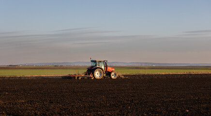 Obraz premium Farmer preparing his field in a tractor