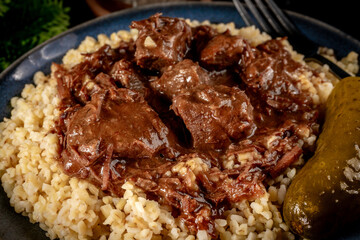 Chunky beef stew with savory sauce, served with bulgur groats.