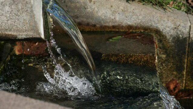 Water pours from a stone trough. Drainage gutter system. Storm water drainage system
