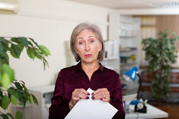 Portrait of pensive business woman with documents in modern office