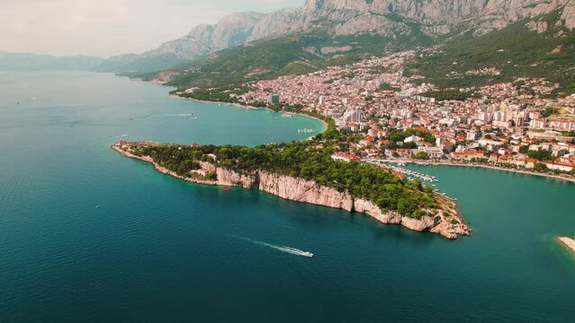 Scenic coast of Makarska town. Overlooking the tranquil Adriatic sea, city radiates charm beneath Biokovo mountain grandeur.